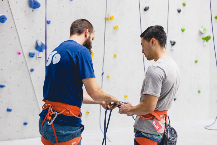 Employee teaching a new climber how to safely belay