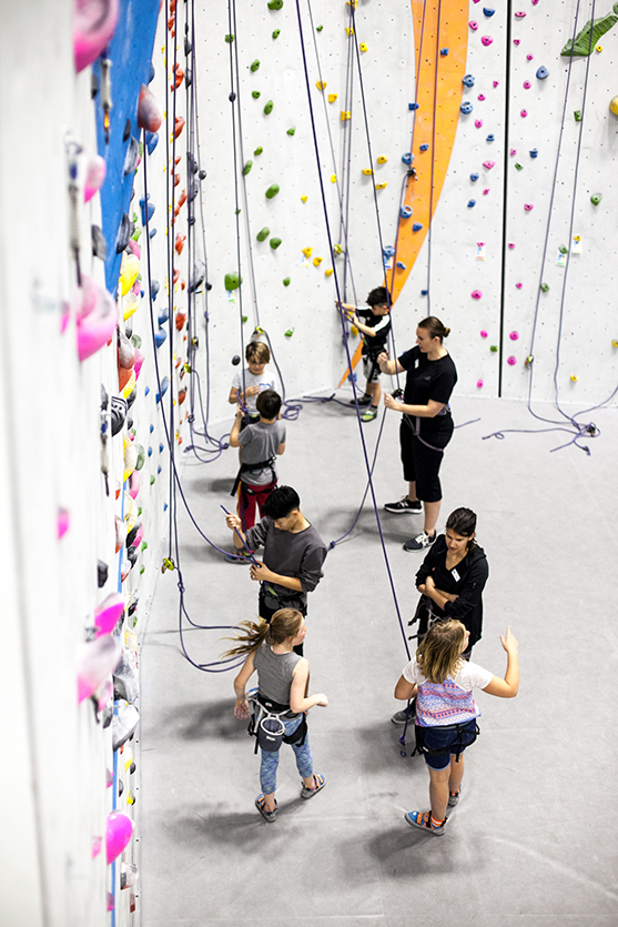 Large group of people in front of a climbing wall
